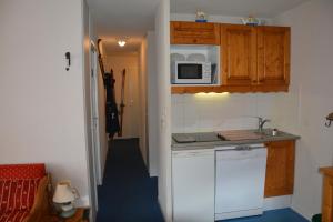 a small kitchen with a sink and a microwave at l'Antre du Cerf in Villarodin-Bourget