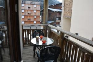 a table and chairs on a balcony with a view at l'Antre du Cerf in Villarodin-Bourget