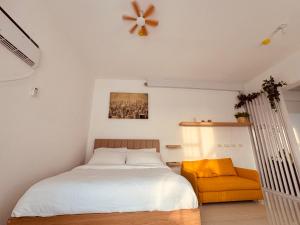a bedroom with a bed and a yellow chair at YukiDo Skynest in Mactan Island +41 photos