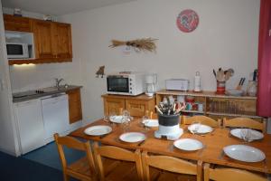a kitchen with a wooden table with chairs and a kitchen with a table at l'Antre du Cerf in Villarodin-Bourget +3 photos