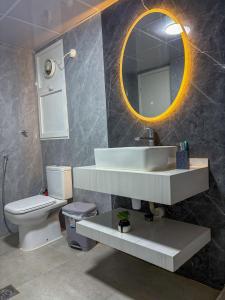 ein Badezimmer mit Waschbecken, Toilette und Spiegel in der Unterkunft Bright Rooms in Dubai