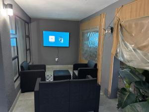 a waiting room with chairs and a flat screen tv at Bryanston Luxury Secure 4BR Haven in Sandton +1 photo