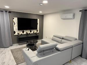 a living room with a couch and a flat screen tv at Bryanston Luxury Secure 4BR Haven in Sandton