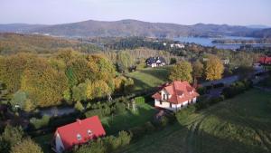 a house with a red roof on a green field at Bieszczady111 in Polańczyk