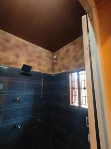 un bagno con un computer portatile appoggiato al muro di Sp Queens Garden a Madurai Altre 18 foto