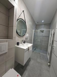 Un baño con lavabo, espejo y ducha. en Pansion Kod Brajlovica, en Tuzla 4 fotos más
