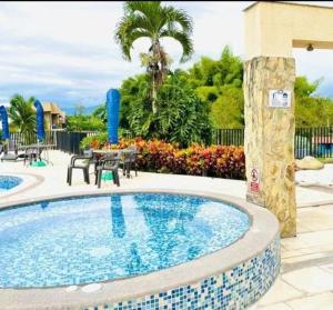 ラ・テバイダにあるApartamento turistico dianaの建物の隣にスイミングプール(テーブル、椅子付) +3枚の写真