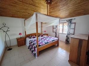 a bedroom with a bed with a canopy at Keur Teranga Nianing in Nianing
