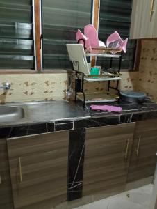 een aanrecht met een laptop erop bij Lucy Chwada hostel in Watamu +6 foto's