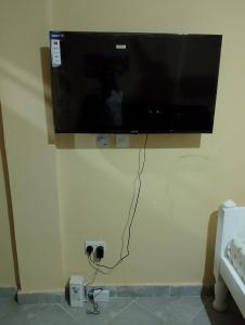 a flat screen tv hanging on a wall at Lucy Chwada hostel in Watamu