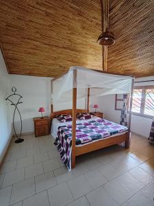 a bedroom with a bed with a canopy at Keur Teranga Nianing in Nianing