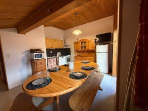 a wooden table in a kitchen with a wooden table at Appartement 5 pers - Draps et serviettes inclus in La Lechere +2 photos