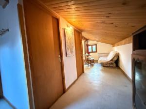 a hallway of a house with a door and a chair at Appartement 5 pers - Draps et serviettes inclus in La Lechere