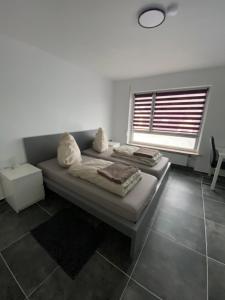 a bedroom with two beds and a window at Moderne 2 Zimmer Wohnung Küche und Bad im Zentrum in Merzig