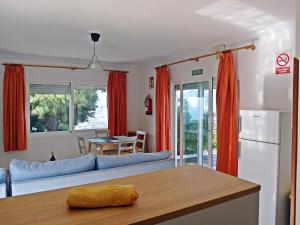 een woonkamer met rode gordijnen en een blauwe bank bij Bungalow Los Guanches 1 in El Paso +14 foto's