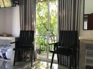 two black chairs in a living room with a window at Everdew Kandy Rooms in Kandy