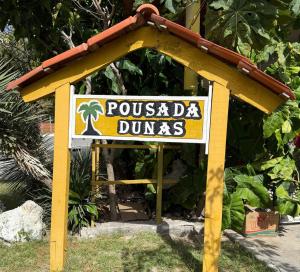a sign for a pucadia dumas restaurant at Pousada dunas in Barroquinha