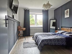 a bedroom with a bed with blue walls and a window at Mente Azul in Pullenreuth