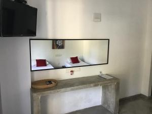a mirror on a wall in a room at Everdew Kandy Rooms in Kandy