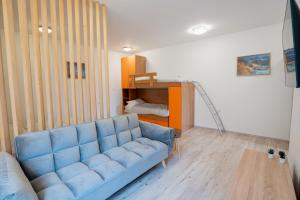 a living room with a blue couch in a room at Studio apartman LuG in Ravna Gora