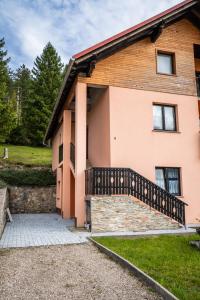 a house with a staircase leading up to it at Studio apartman LuG in Ravna Gora