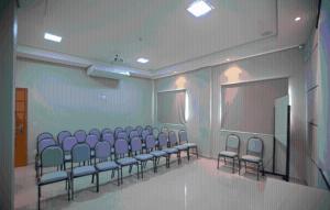 a room with a bunch of chairs and a screen at Skala Traveling Hotel in Cuiabá