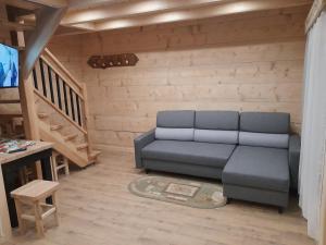 a living room with a couch and a staircase at Domek GAWRA in Ząb