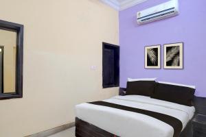 a bedroom with a large bed with purple walls at Hotel O Durgapuri Metro Station Lucknow Formerly Pal Awadh in Bādshāhnagar