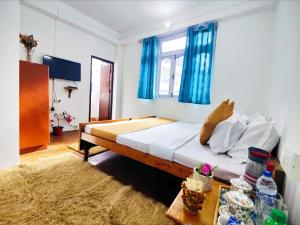 a bedroom with a bed with blue curtains at Jo'stel Hotel Winter Green- MG Marg in Gangtok