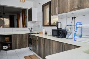 a kitchen with wooden cabinets and a blender on the counter at Darflings Haven-Diani in Ukunda