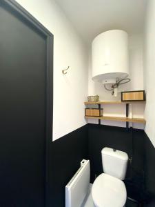 a bathroom with a white toilet and a white lamp at La Suite Nocturne Climatisée avec écran Cinéma in Fère-en-Tardenois +50 photos