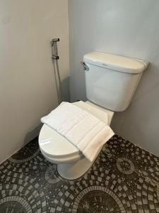a bathroom with a toilet with a towel on it at Phayam Paradise Resort in Ko Phayam