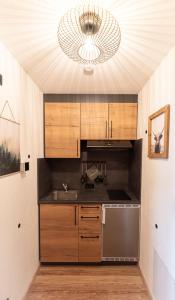 a kitchen with a stainless steel sink and a chandelier at Bienenhaus #Bergblick im Sonnenhof in Seeg