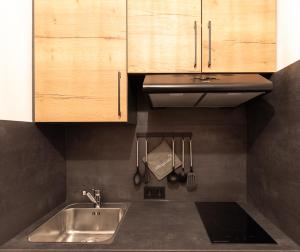 a kitchen with a sink and wooden cabinets and utensils at Bienenhaus #Bergblick im Sonnenhof in Seeg +66 photos