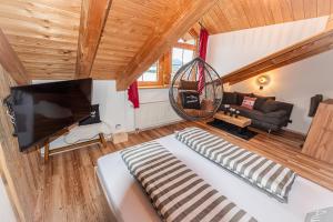 a living room with a large television and a couch at Bienenhaus #Bergblick im Sonnenhof in Seeg