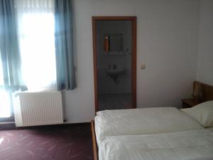 a bedroom with two beds and a bathroom with a sink at Landhotel Zur Krone in Kieselbach