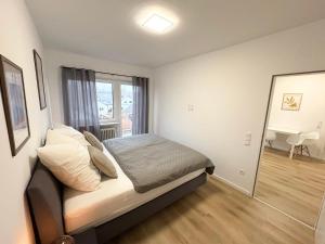um pequeno quarto com uma cama e uma janela em HUGOS Design Apartment em Wiesloch