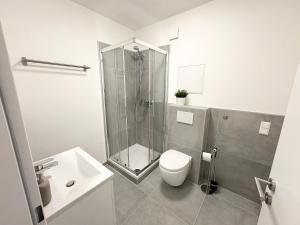 um banheiro com chuveiro, vaso sanitário e pia em HUGOS Design Apartment em Wiesloch