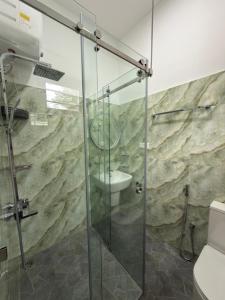 une salle de bain avec une douche en verre et des toilettes dans l'établissement Villa Sandakelum Luxury, à Weligama