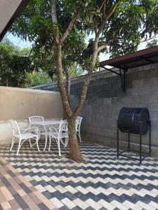 une table et des chaises assises à côté d'un arbre dans l'établissement Villa Sandakelum Luxury, à Weligama
