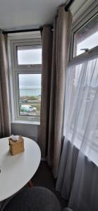 a room with a window with a white table and a white table at Black Sheep Lodge in Holyhead