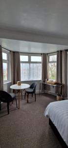 a hotel room with a bed and a table and chairs at Black Sheep Lodge in Holyhead