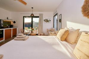 Un dormitorio con una gran cama blanca y una sala de estar. en Casa del Aljibe - El Estudio, en La Asomada