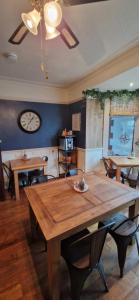 a dining room with a wooden table and a clock at Black Sheep Lodge in Holyhead