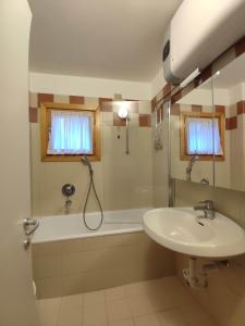 a bathroom with a sink and a tub and a shower at AL18 bilocale in Santa Caterina Valfurva