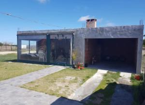 ein Haus mit einer großen Glastür in der Unterkunft Casa en Cuchilla Alta Biarritz in Cuchilla Alta