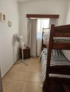 Zimmer mit 2 Etagenbetten und einem Ventilator in der Unterkunft Casa en Cuchilla Alta Biarritz in Cuchilla Alta