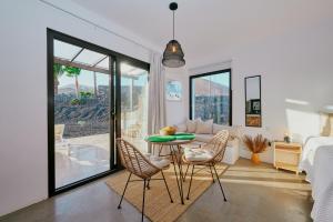Un dormitorio con una cama y una mesa y sillas. en Casa del Aljibe - El Estudio, en La Asomada