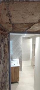 Un baño con lavabo y pared de piedra. en Casa de poble Cal Casellas, en San Martín Sasgayolas
