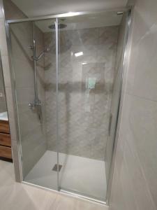 a shower with a glass door in a bathroom at Casa de poble Cal Casellas in San Martín Sasgayolas